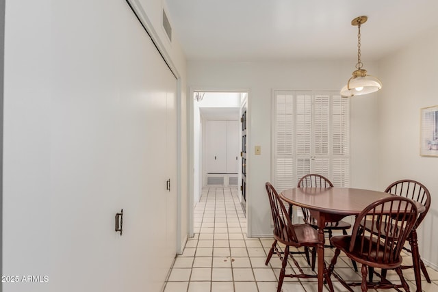 dining area featuring baseboards, visible vents, and light tile patterned flooring