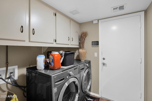 laundry room featuring cabinets and washer and clothes dryer