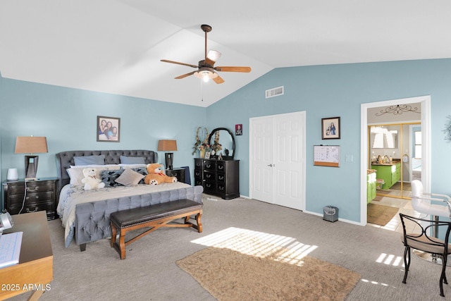 carpeted bedroom with ceiling fan, vaulted ceiling, and a closet