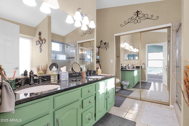 bathroom with vanity, lofted ceiling, tile patterned floors, and a shower with shower door