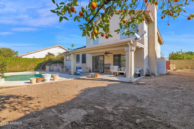 rear view of house with a fenced in pool, ceiling fan, and a patio area