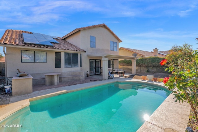 view of pool with exterior kitchen and a patio area