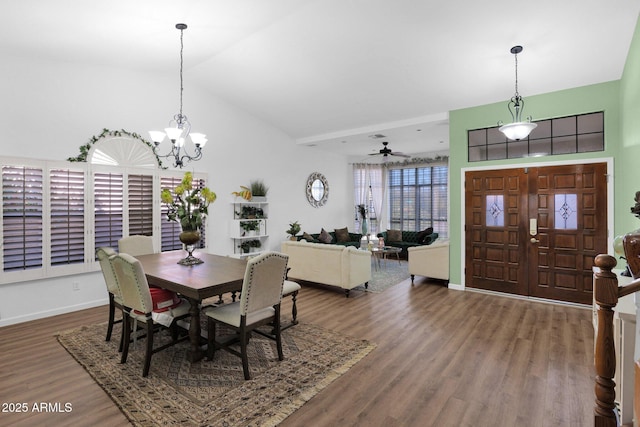 dining area featuring ceiling fan with notable chandelier, wood-type flooring, and vaulted ceiling