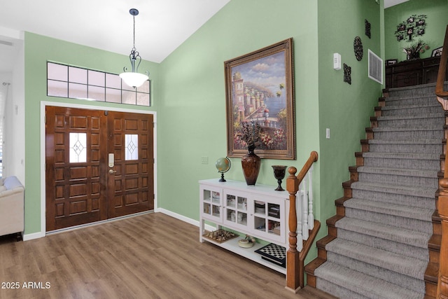 foyer entrance with lofted ceiling and wood-type flooring