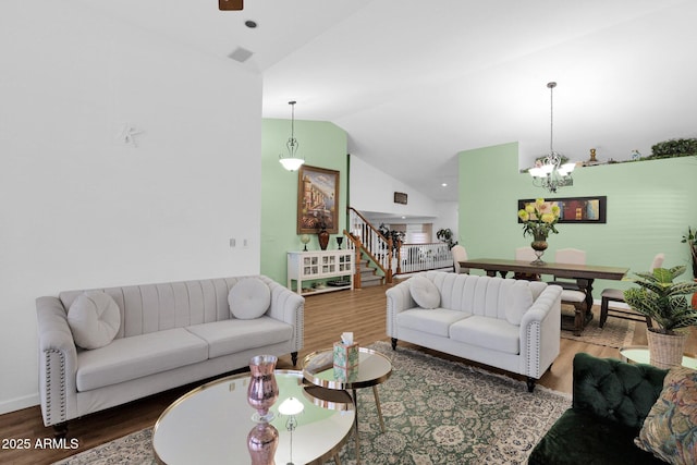 living room featuring hardwood / wood-style flooring, a chandelier, and high vaulted ceiling