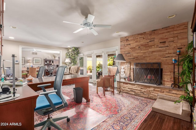 office featuring a ceiling fan, wood finished floors, and a fireplace
