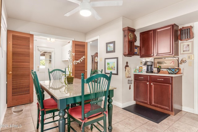 dining room featuring baseboards, ceiling fan, and light tile patterned floors