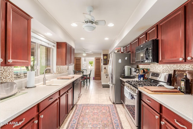 kitchen with light countertops, a ceiling fan, reddish brown cabinets, a sink, and appliances with stainless steel finishes