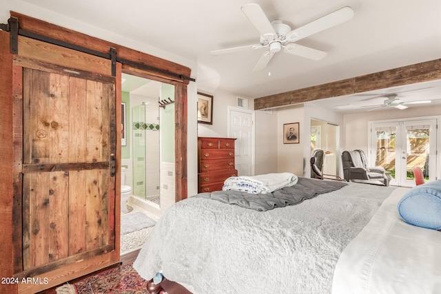 bedroom with a barn door, french doors, connected bathroom, and ceiling fan