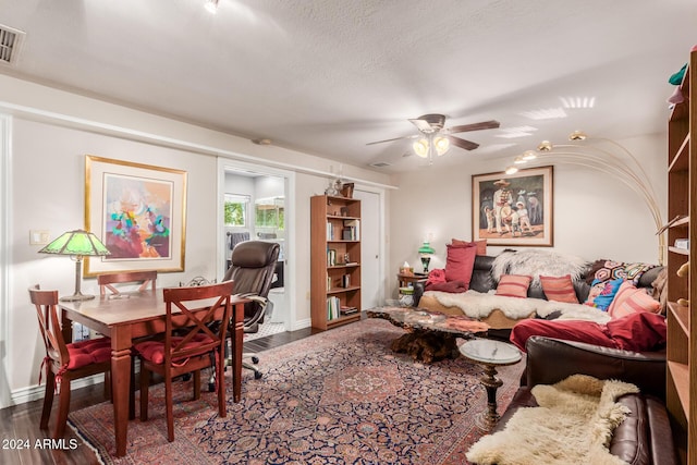 living room featuring baseboards, a ceiling fan, dark wood-type flooring, and visible vents
