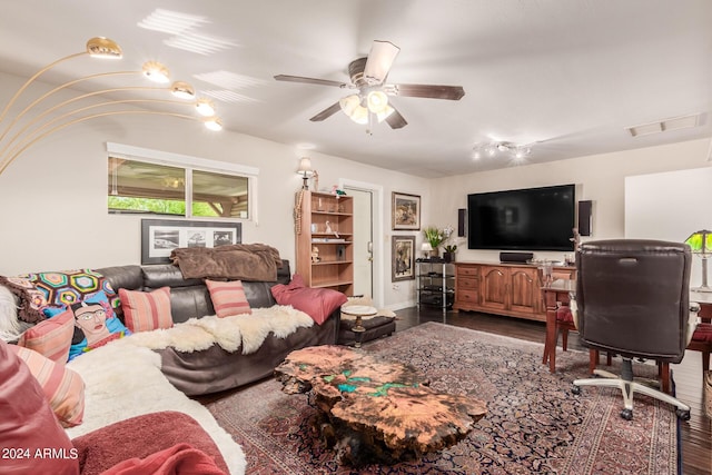 living room with wood finished floors, visible vents, and ceiling fan