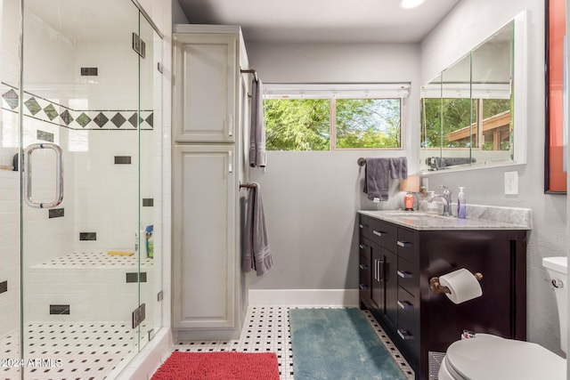 full bath with a shower stall, toilet, vanity, and baseboards