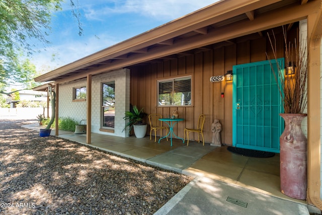 view of exterior entry with a patio area