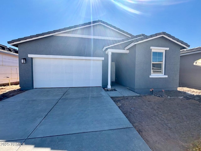 ranch-style house with driveway, an attached garage, and stucco siding