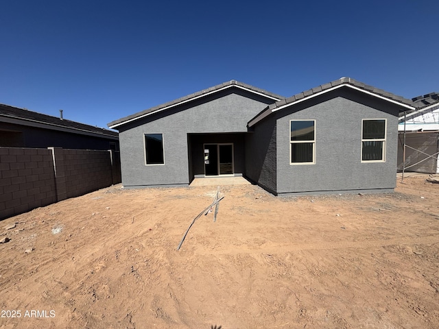 view of front of house with fence and stucco siding