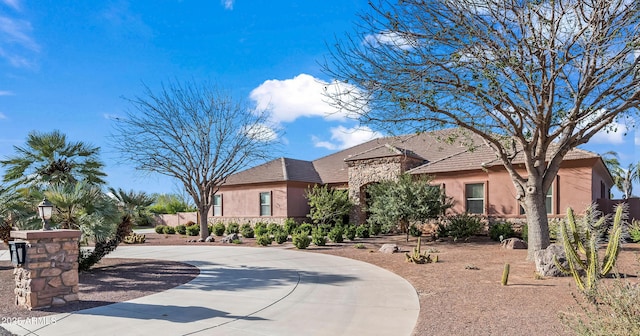 view of front of property featuring stone siding, a tile roof, and stucco siding