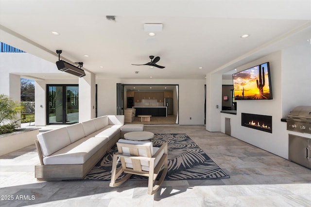 living room featuring recessed lighting and a lit fireplace