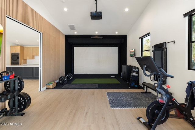 game room with light wood finished floors, washer / clothes dryer, golf simulator, a sink, and recessed lighting