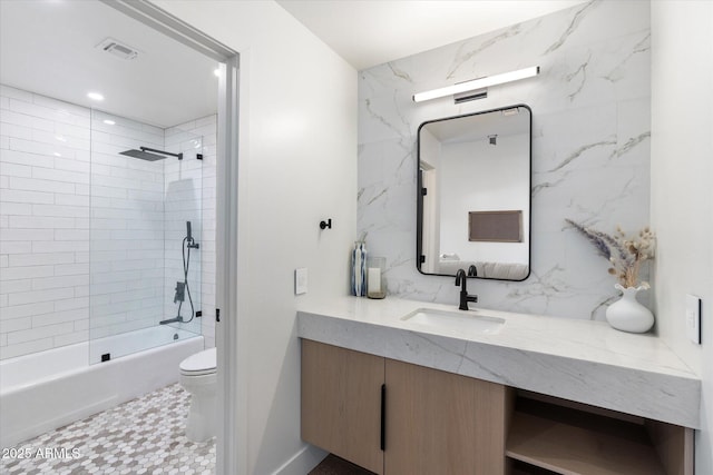 bathroom with toilet, visible vents, vanity, shower / bathing tub combination, and backsplash