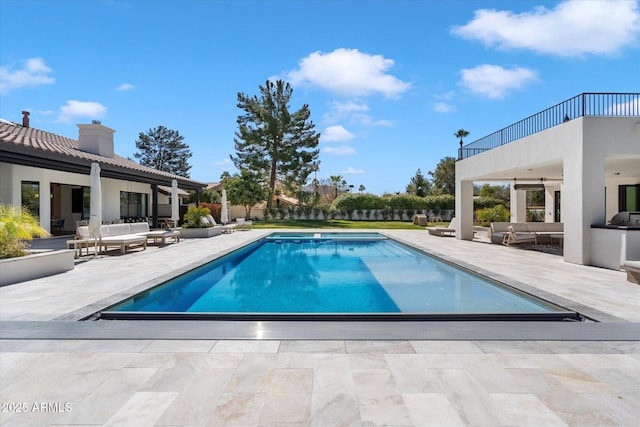 pool featuring a patio and an outdoor living space