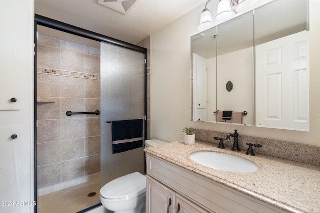 bathroom featuring a shower with door, vanity, and toilet