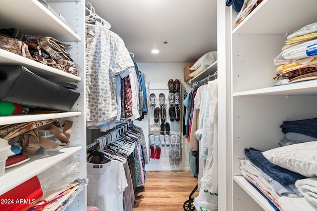 walk in closet with light hardwood / wood-style floors