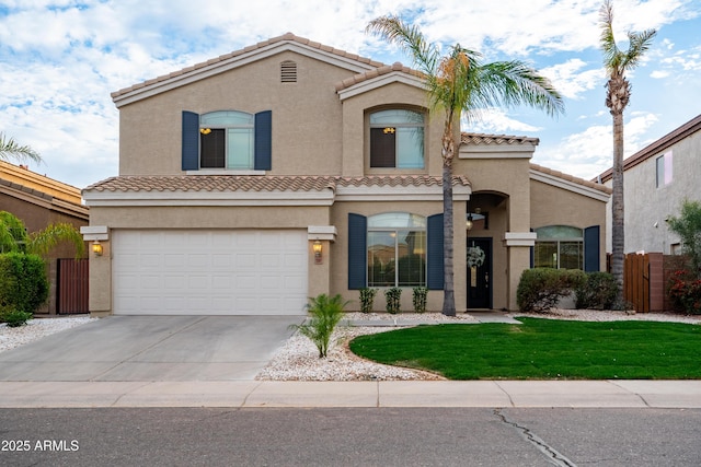 mediterranean / spanish-style house with a tile roof, fence, concrete driveway, and stucco siding