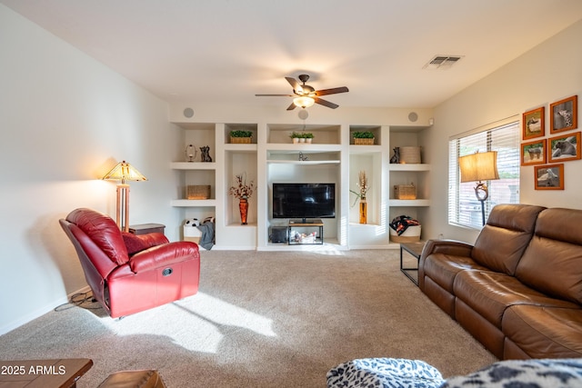 carpeted living room featuring built in features, visible vents, and ceiling fan