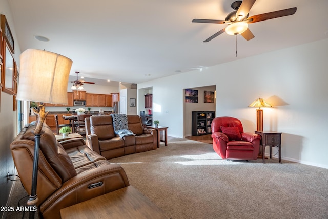 living room with light carpet, ceiling fan, and baseboards