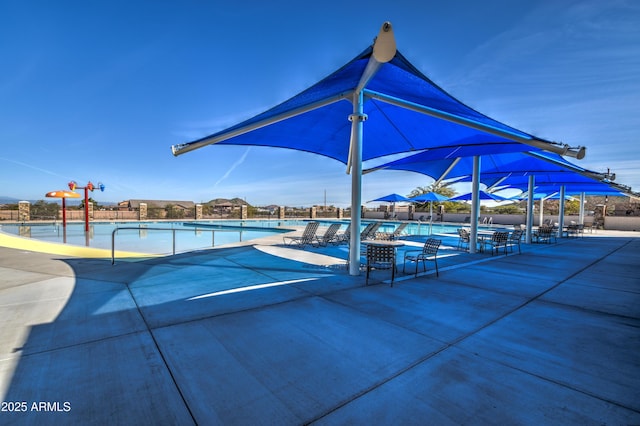 community pool featuring a patio area and fence