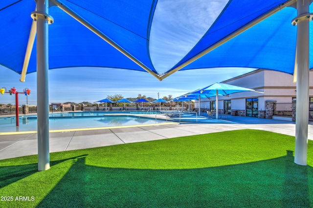 pool with a patio area, fence, and a lawn