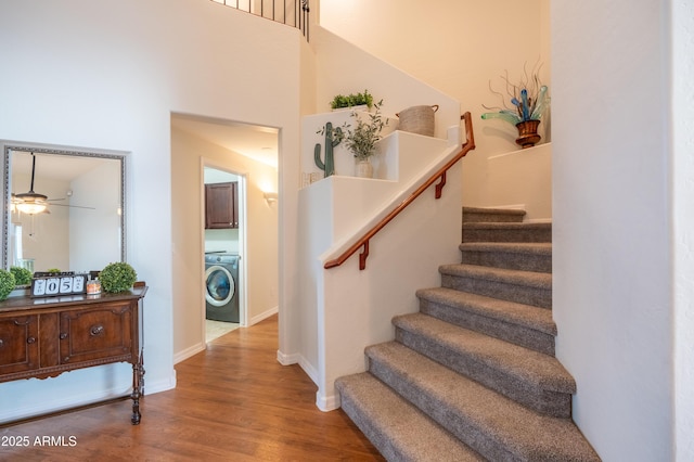 stairs featuring washer / dryer, baseboards, and wood finished floors