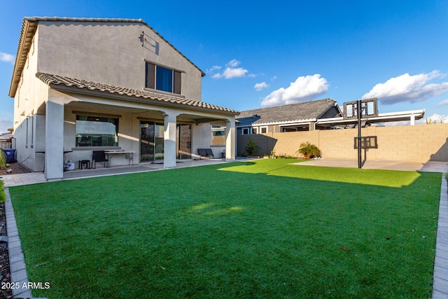 rear view of property featuring a patio area and a lawn