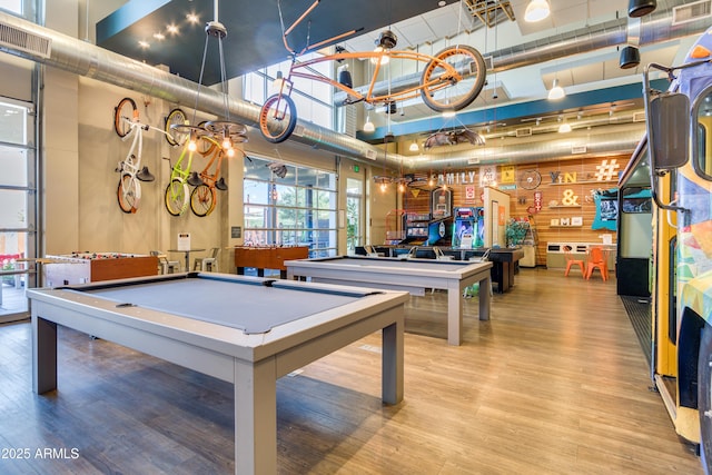 recreation room with a high ceiling, hardwood / wood-style flooring, and billiards