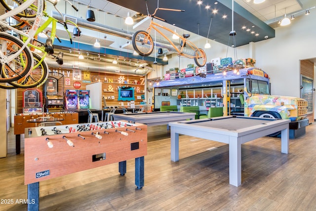 recreation room featuring pool table, hardwood / wood-style floors, and a high ceiling