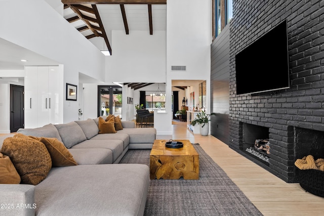 101 E Linger Ln, Phoenix, AZ 85020 - living room with wood finished floors, high vaulted ceiling, a brick fireplace, and beam ceiling