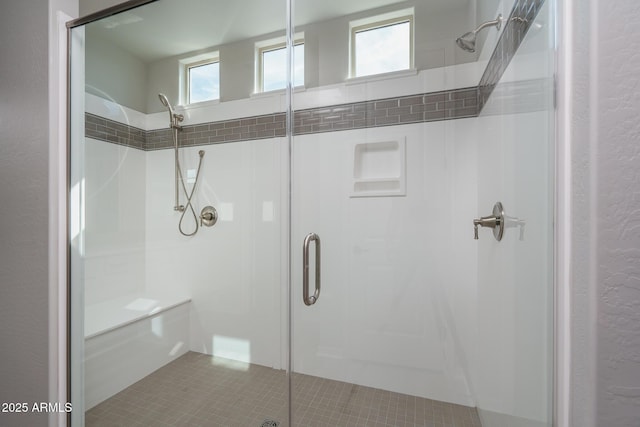 bathroom with a shower stall and tile patterned floors