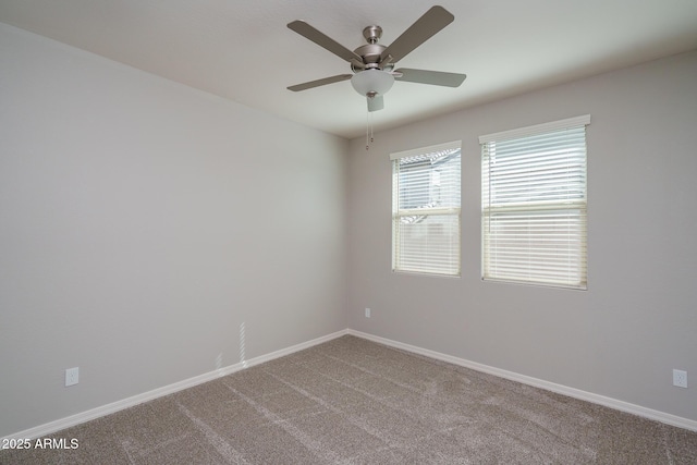 spare room featuring a ceiling fan, carpet, and baseboards