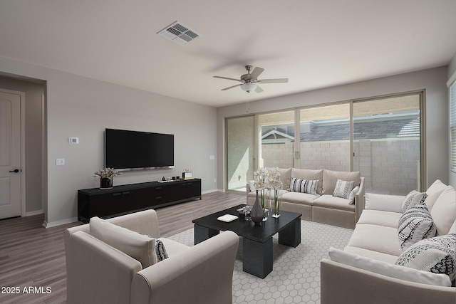 living area with light wood-type flooring, visible vents, and baseboards