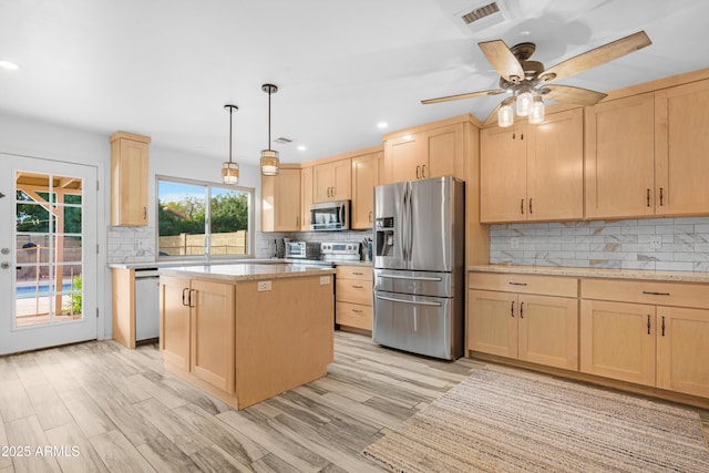 kitchen featuring a center island, light hardwood / wood-style flooring, hanging light fixtures, light brown cabinets, and stainless steel appliances