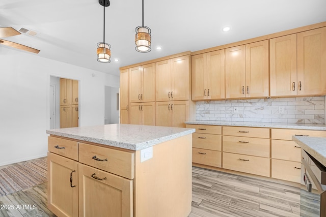 kitchen with a kitchen island, decorative backsplash, light brown cabinetry, and decorative light fixtures