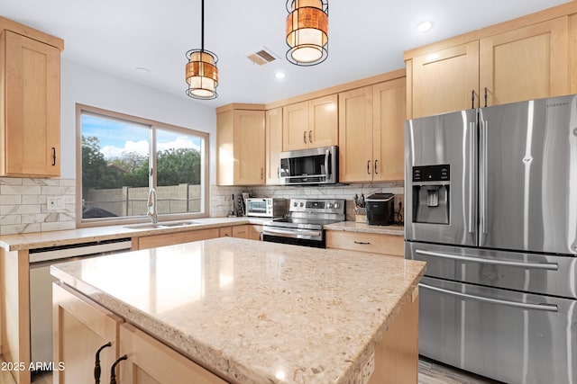 kitchen with sink, decorative light fixtures, stainless steel appliances, and light brown cabinets