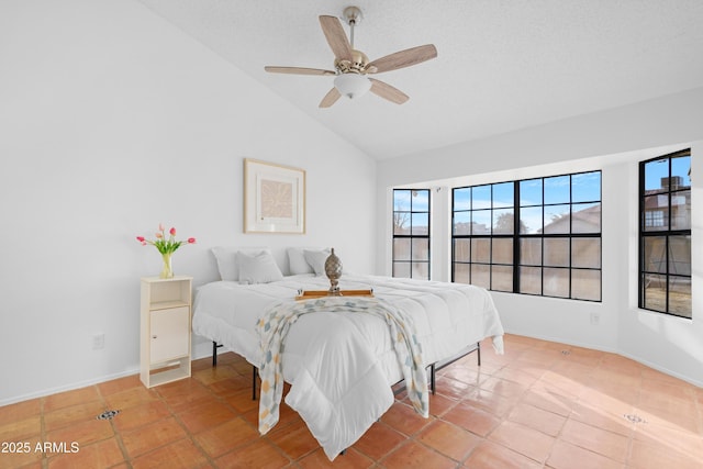 tiled bedroom featuring vaulted ceiling, ceiling fan, and a textured ceiling