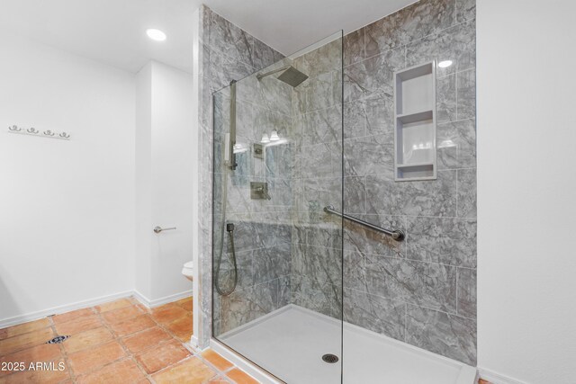 bathroom with a tile shower, tile patterned flooring, and toilet