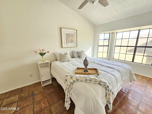 tiled bedroom featuring vaulted ceiling, ceiling fan, and a textured ceiling