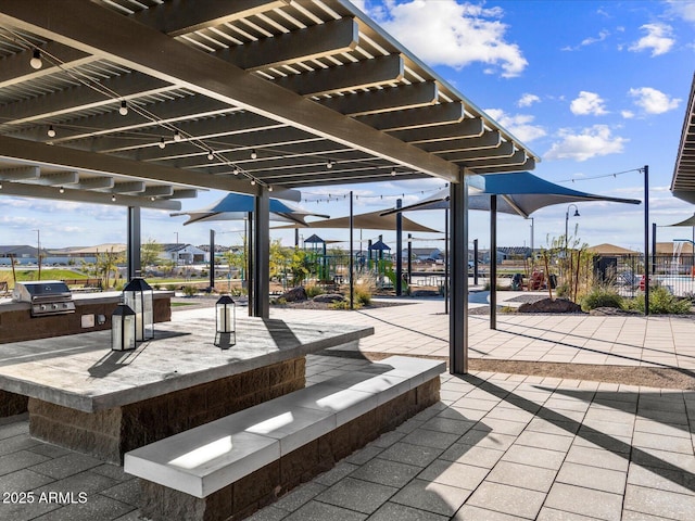 view of patio / terrace with grilling area, fence, a pergola, and an outdoor kitchen