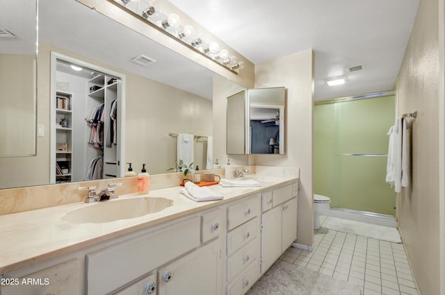 bathroom with toilet, vanity, and tile patterned floors