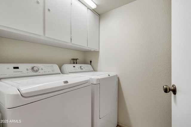 washroom featuring cabinets and washer and dryer