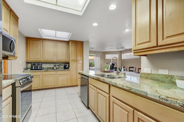 kitchen featuring ceiling fan, light brown cabinetry, sink, and appliances with stainless steel finishes