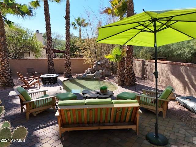 view of patio with an outdoor living space with a fire pit